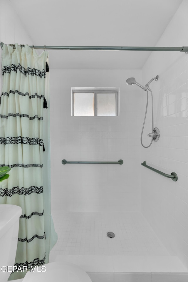 bathroom with curtained shower and toilet