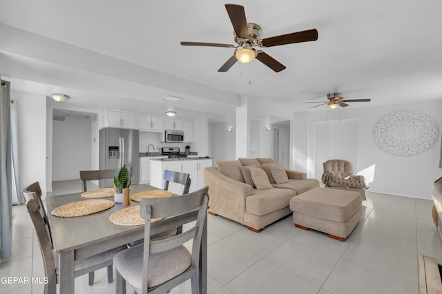 tiled dining room featuring ceiling fan and sink