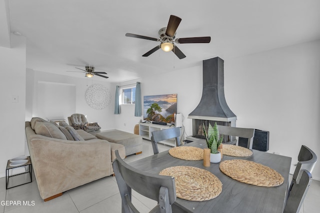 tiled dining space featuring ceiling fan and a wood stove