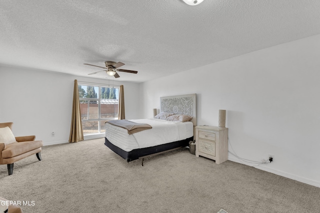 bedroom with ceiling fan, light colored carpet, and a textured ceiling