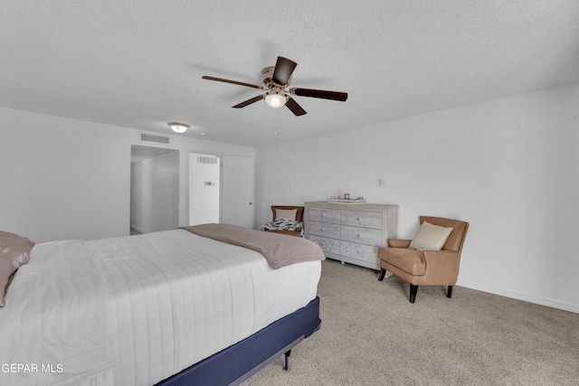 bedroom featuring ceiling fan, a textured ceiling, and light carpet