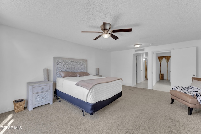 carpeted bedroom with a textured ceiling and ceiling fan