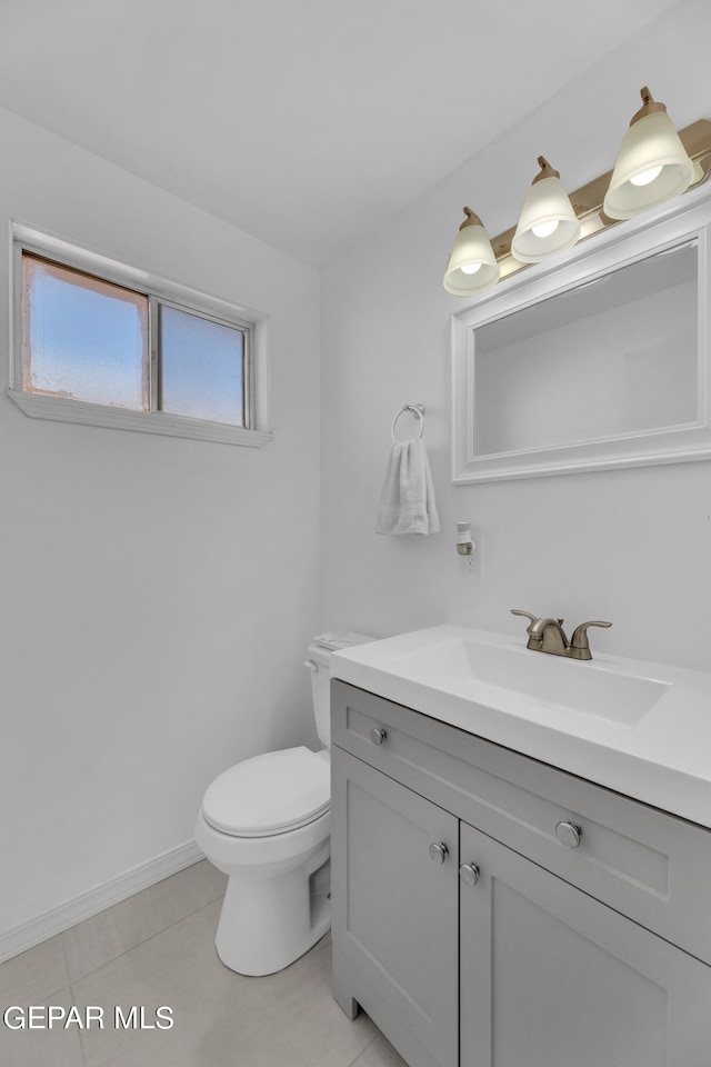 bathroom with tile patterned flooring, vanity, and toilet