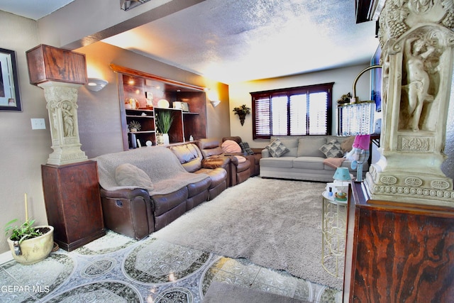 carpeted living room with a textured ceiling and ornate columns