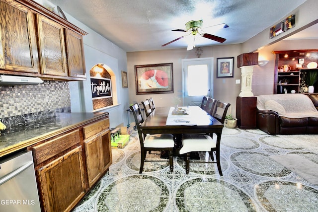 dining area featuring decorative columns, ceiling fan, and a textured ceiling