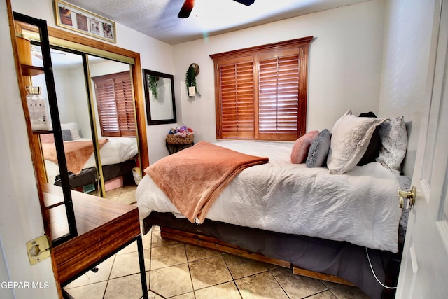 bedroom featuring ceiling fan, a closet, and light tile patterned floors