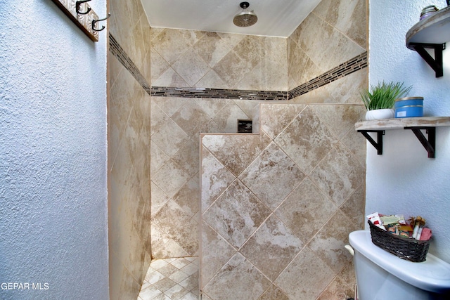 bathroom featuring toilet and tiled shower