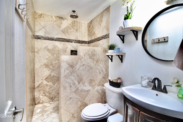 bathroom featuring tiled shower, vanity, and toilet