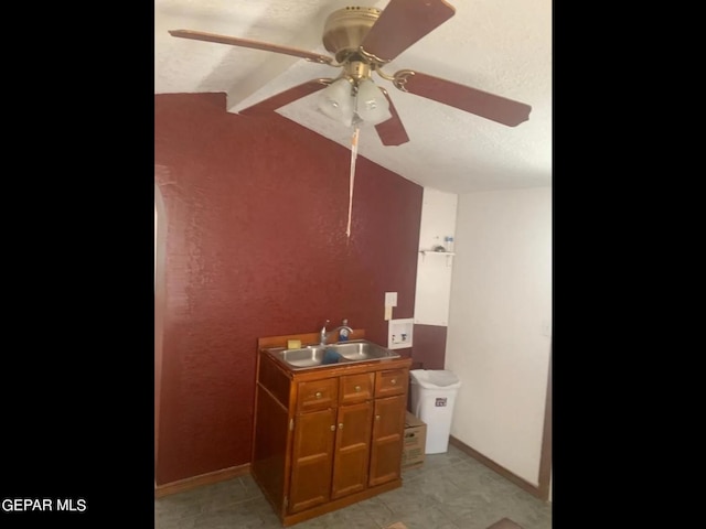 bathroom featuring vaulted ceiling with beams, sink, a textured ceiling, and ceiling fan