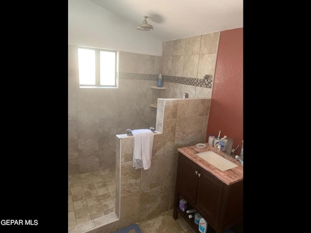 bathroom featuring a tile shower and vanity