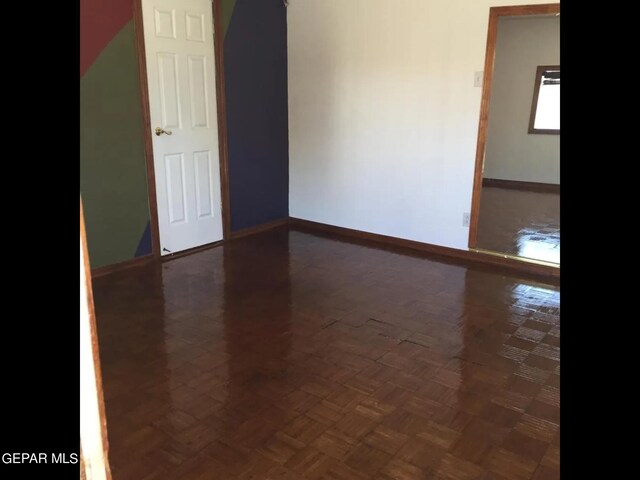 empty room with dark parquet flooring