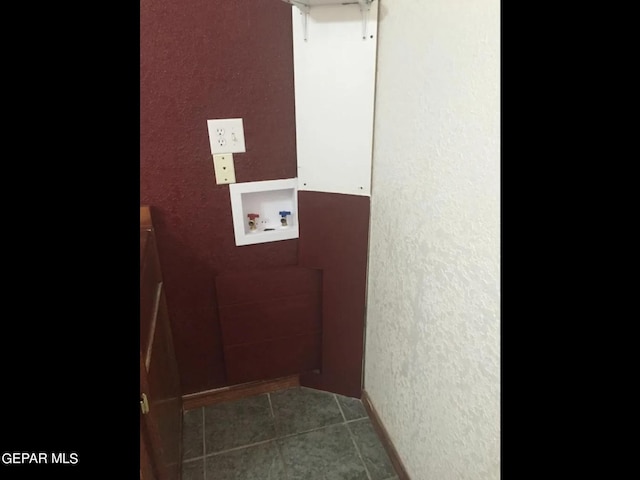 laundry area featuring dark tile patterned floors and washer hookup