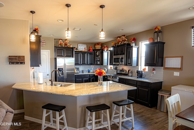 kitchen featuring appliances with stainless steel finishes, backsplash, sink, and dark hardwood / wood-style floors