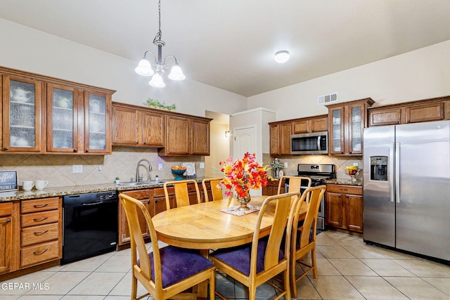 kitchen with a notable chandelier, stainless steel appliances, backsplash, and light stone countertops