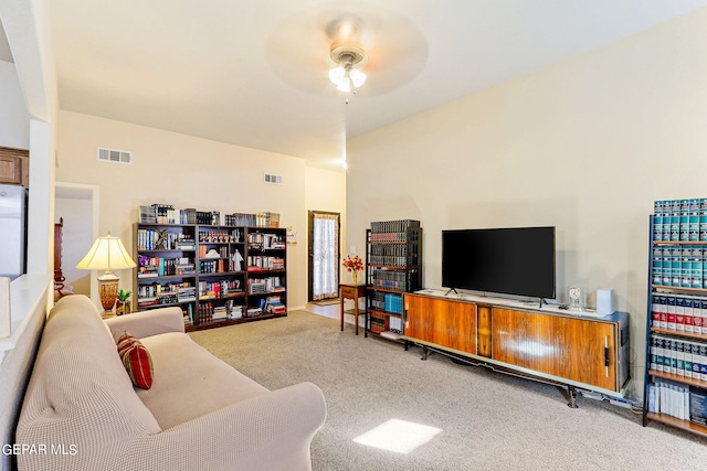 carpeted living room with ceiling fan