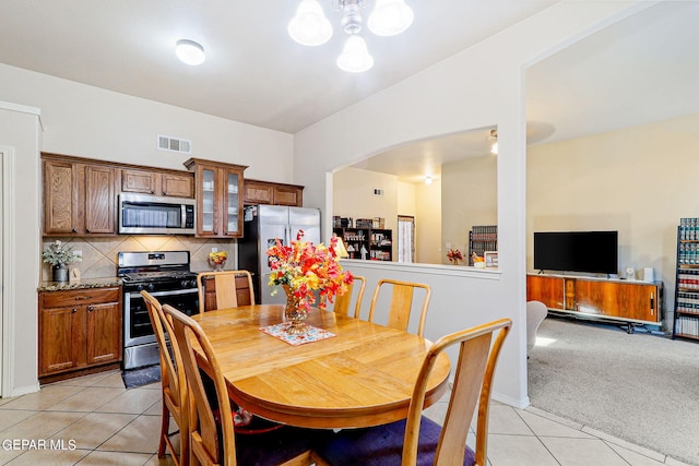 dining space with an inviting chandelier and light tile patterned flooring