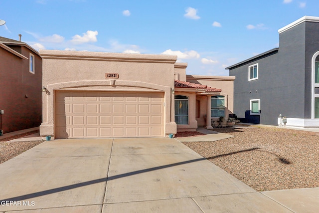 pueblo revival-style home featuring a garage