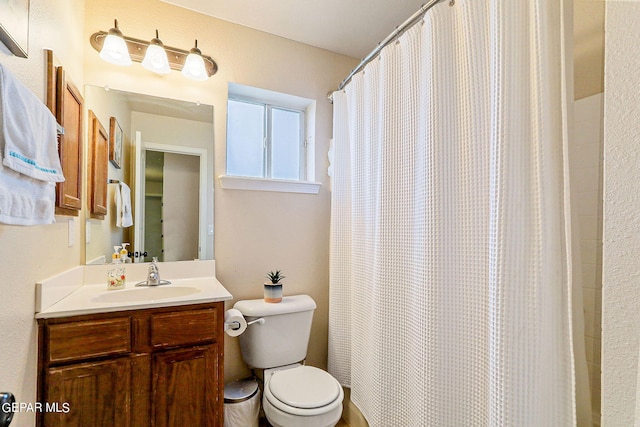 bathroom featuring a shower with curtain, vanity, and toilet