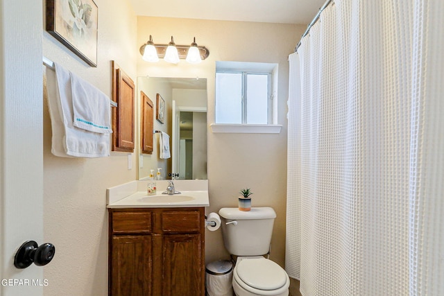 bathroom featuring a shower with curtain, vanity, and toilet