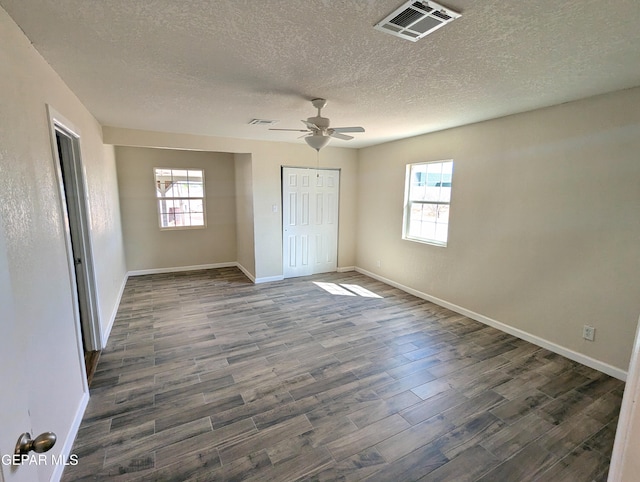 unfurnished room with a textured ceiling, dark hardwood / wood-style floors, and ceiling fan