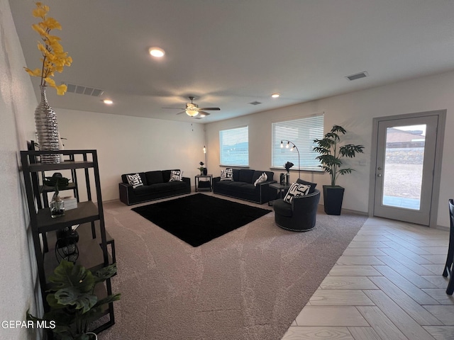 living room featuring ceiling fan and a healthy amount of sunlight