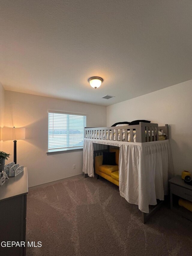 bedroom with a textured ceiling and carpet flooring