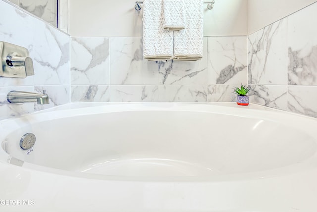 bathroom featuring tile walls and tiled tub