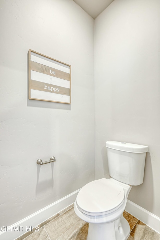 bathroom with hardwood / wood-style flooring and toilet