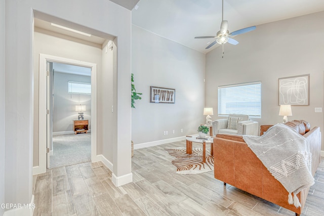 living room featuring light hardwood / wood-style floors, vaulted ceiling, and ceiling fan