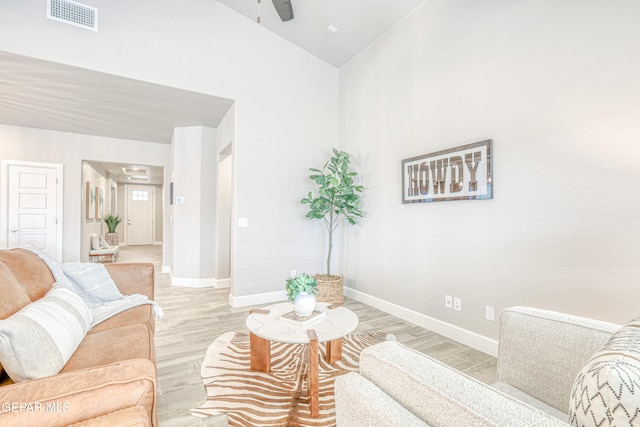 living room featuring ceiling fan, light hardwood / wood-style floors, and high vaulted ceiling