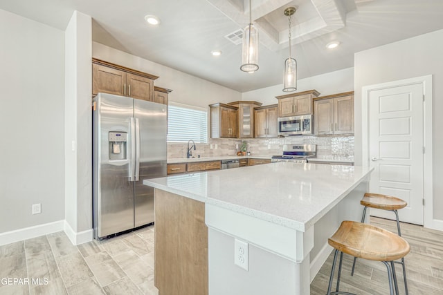 kitchen featuring a center island, light stone countertops, appliances with stainless steel finishes, light hardwood / wood-style floors, and a breakfast bar area