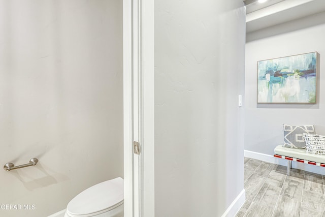 bathroom with hardwood / wood-style floors and toilet