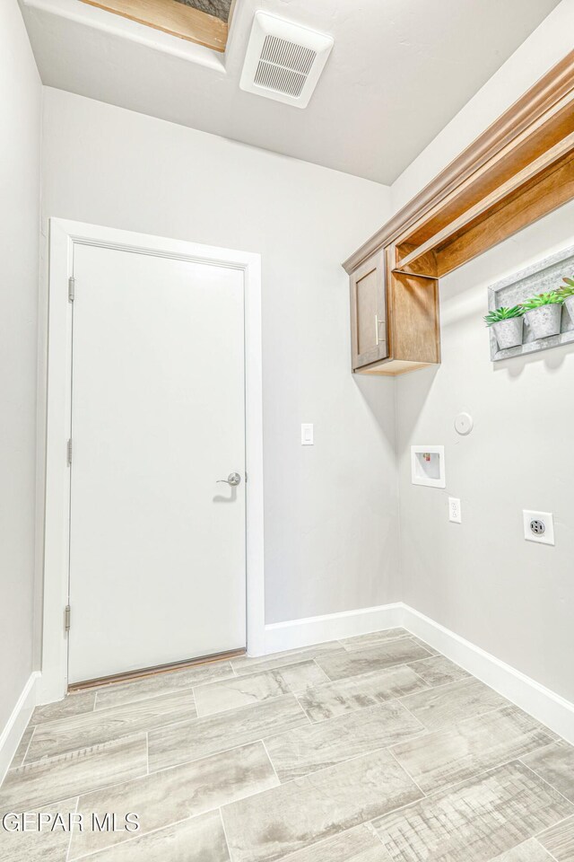 clothes washing area featuring cabinets, washer hookup, light wood-type flooring, and hookup for an electric dryer