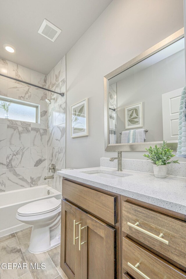 full bathroom with tile patterned floors, vanity, toilet, and tiled shower / bath