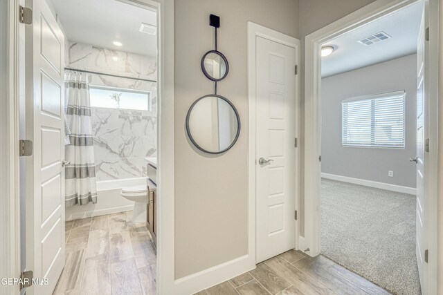 full bathroom with toilet, hardwood / wood-style floors, vanity, and shower / tub combo with curtain