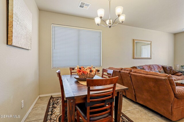 tiled dining room featuring a chandelier