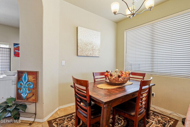 dining area with a notable chandelier and light tile patterned flooring