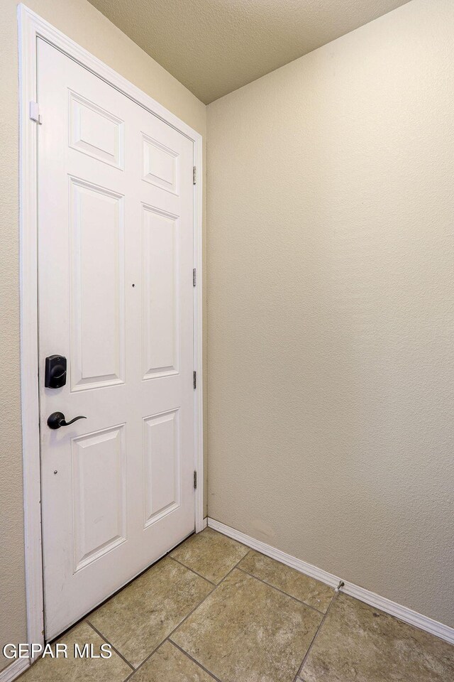 entryway featuring a textured ceiling and light tile patterned floors