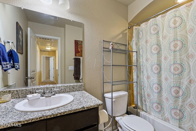 full bathroom featuring shower / bath combination with curtain, vanity, and toilet