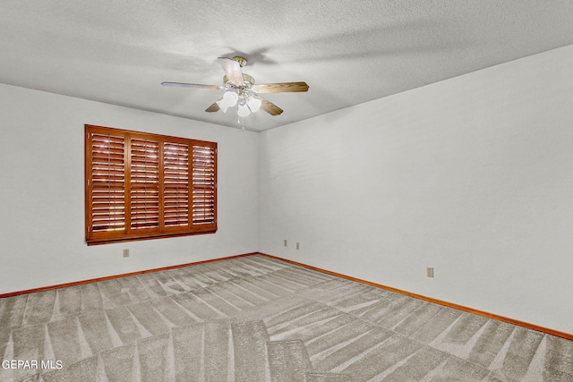 carpeted spare room with a textured ceiling and ceiling fan