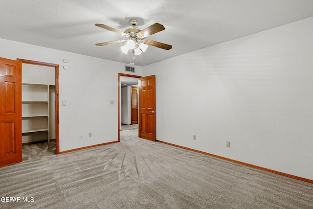 spare room with ceiling fan and light carpet