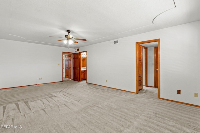 carpeted spare room featuring a textured ceiling and ceiling fan