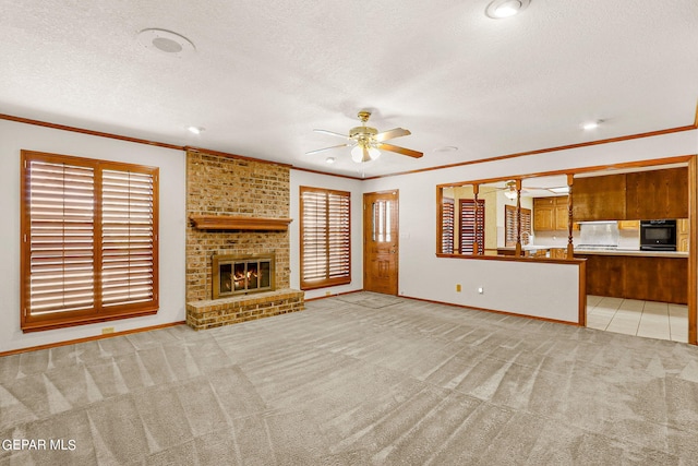 unfurnished living room featuring plenty of natural light, light carpet, ceiling fan, and a brick fireplace