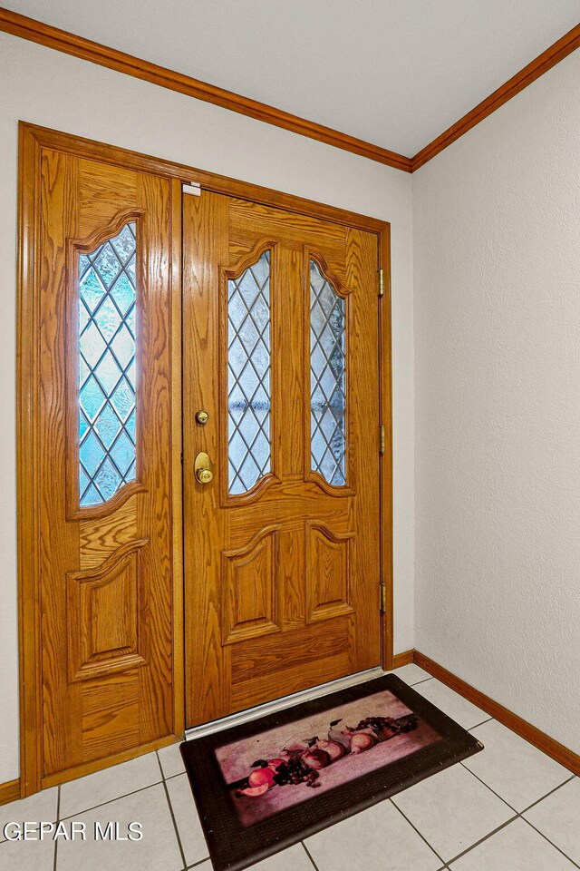 tiled foyer entrance featuring crown molding