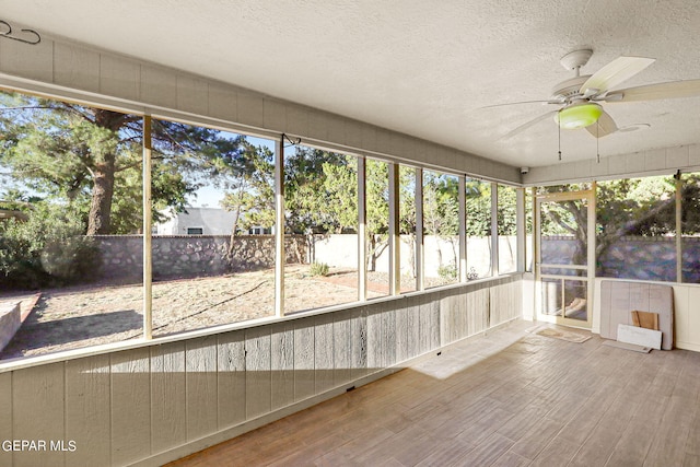 unfurnished sunroom with ceiling fan