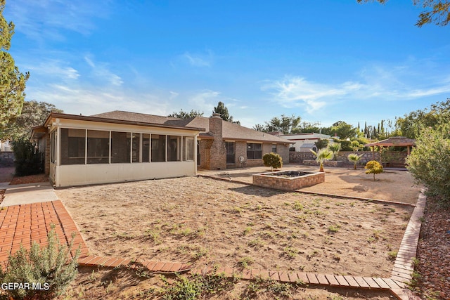 rear view of property featuring a patio and a sunroom