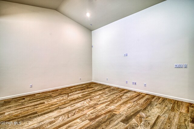 empty room featuring wood-type flooring and lofted ceiling