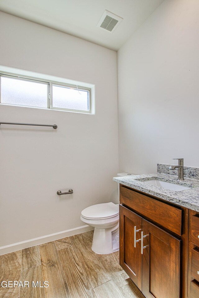 bathroom featuring hardwood / wood-style floors, vanity, and toilet