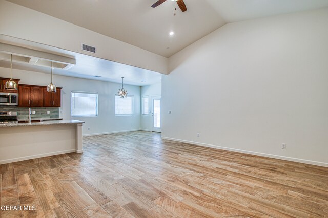 unfurnished living room featuring lofted ceiling, light hardwood / wood-style floors, and ceiling fan