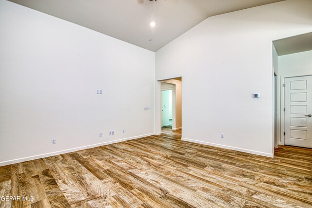 unfurnished room featuring wood-type flooring and vaulted ceiling